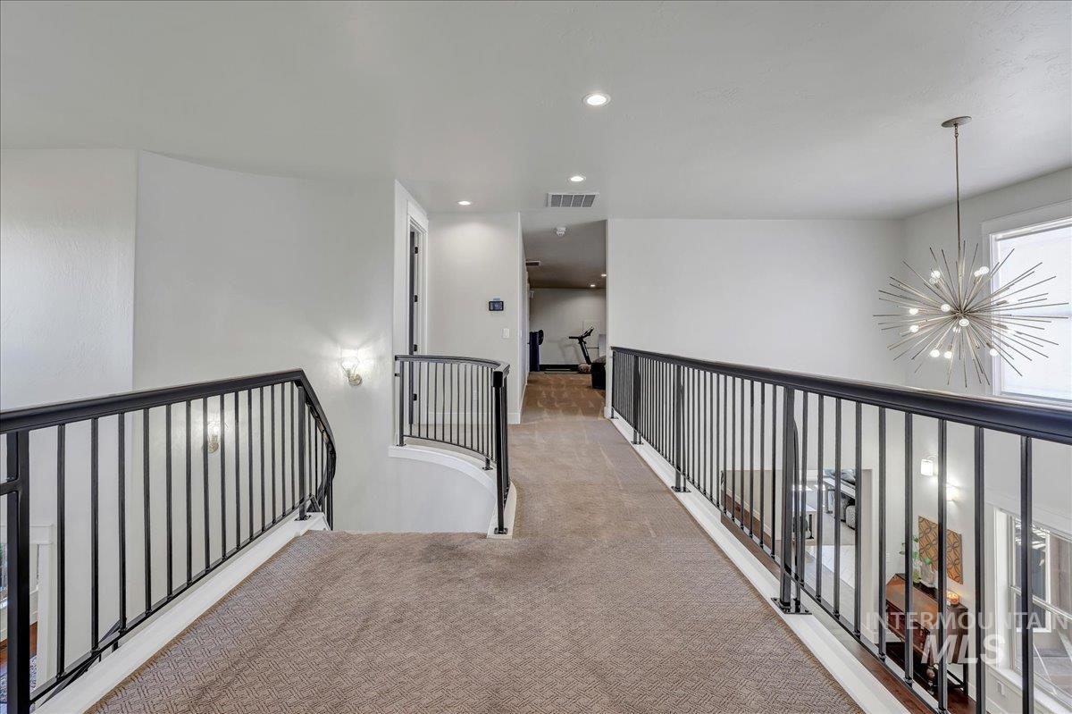 Corridor with carpet flooring, a chandelier, recessed lighting, and an upstairs landing