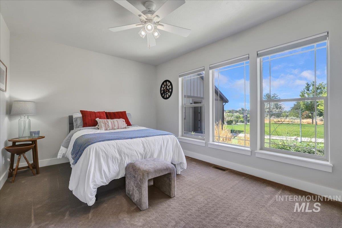 Carpeted bedroom with baseboards and ceiling fan