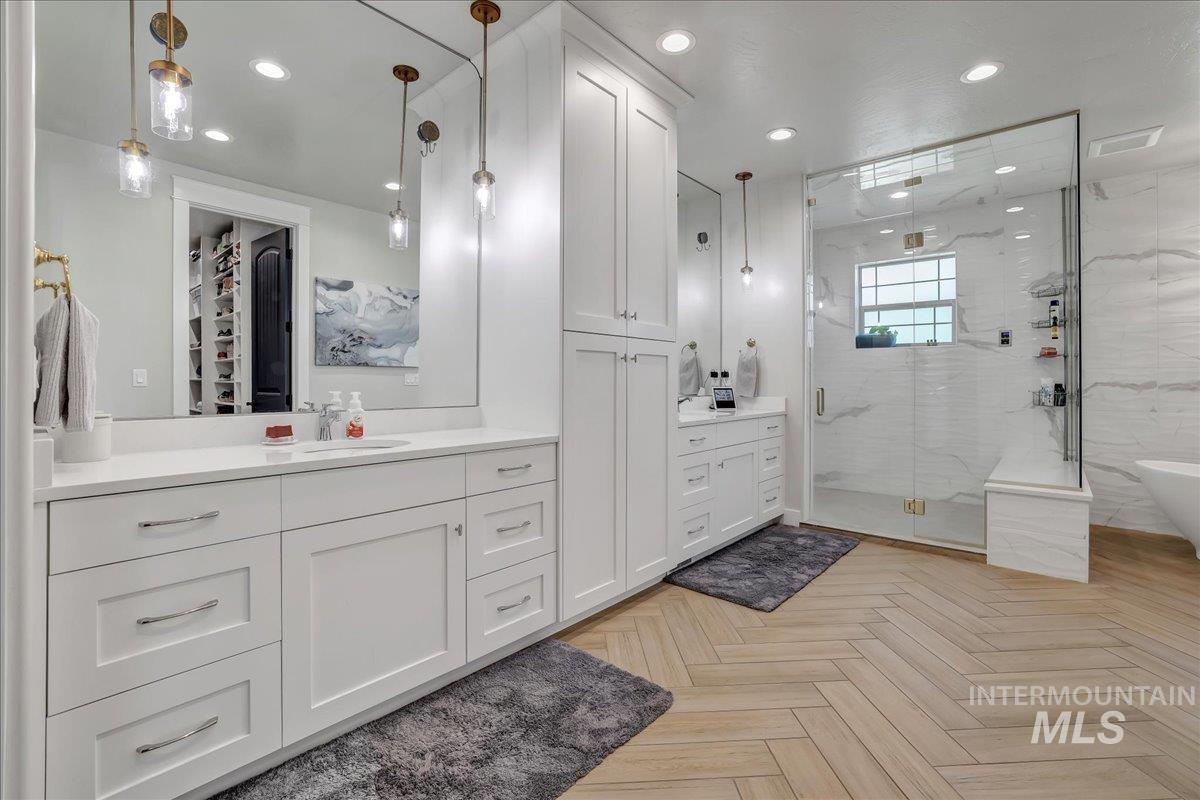 Full bath featuring a marble finish shower, vanity, recessed lighting, and a freestanding tub
