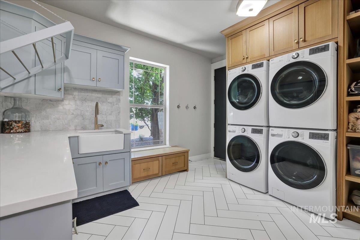 Laundry room with cabinet space, stacked washer and clothes dryer, and washer and dryer