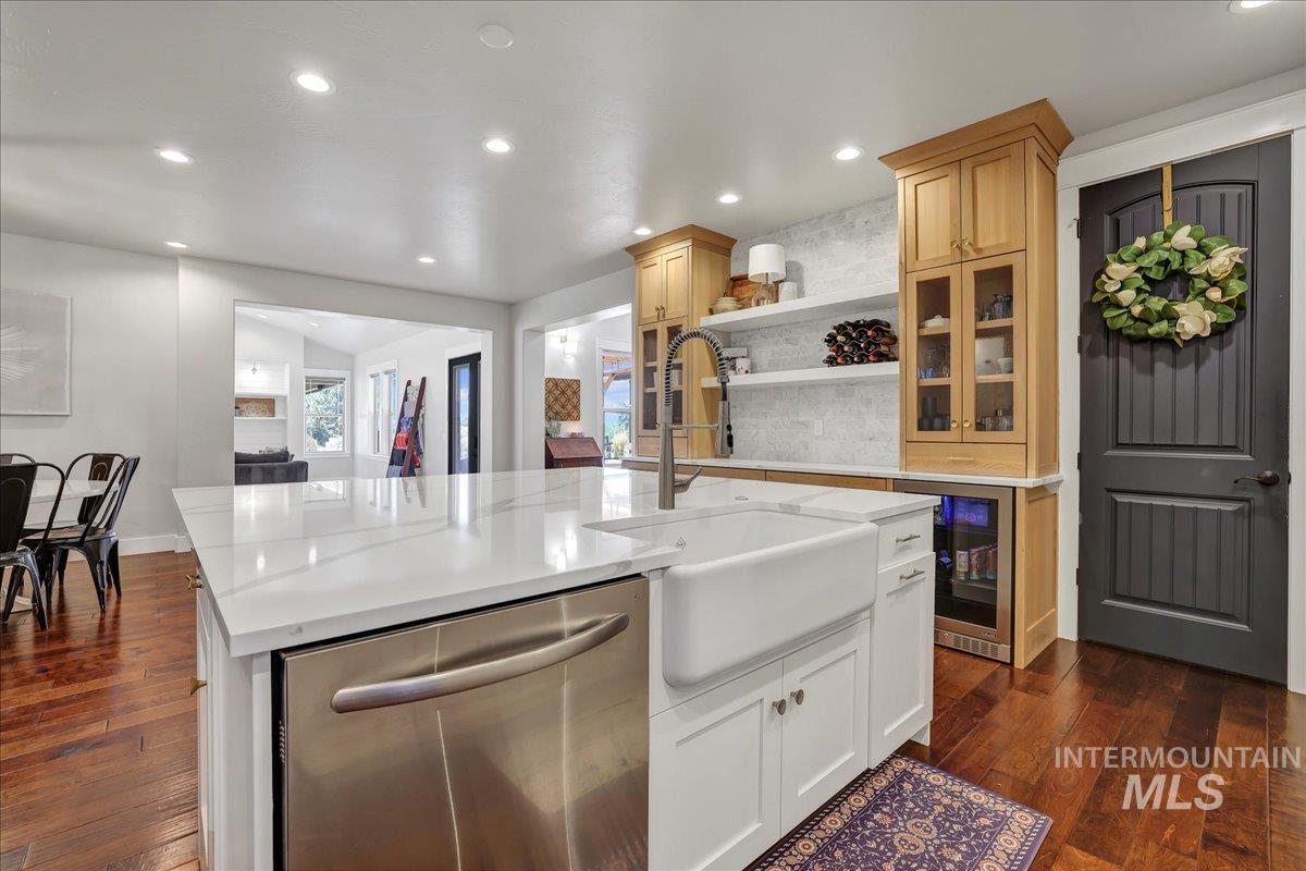 Kitchen featuring stainless steel dishwasher, wine cooler, recessed lighting, dark wood-style flooring, and open shelves