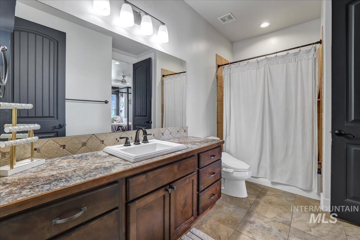 Full bath featuring vanity, ceiling fan, and shower / bath combo