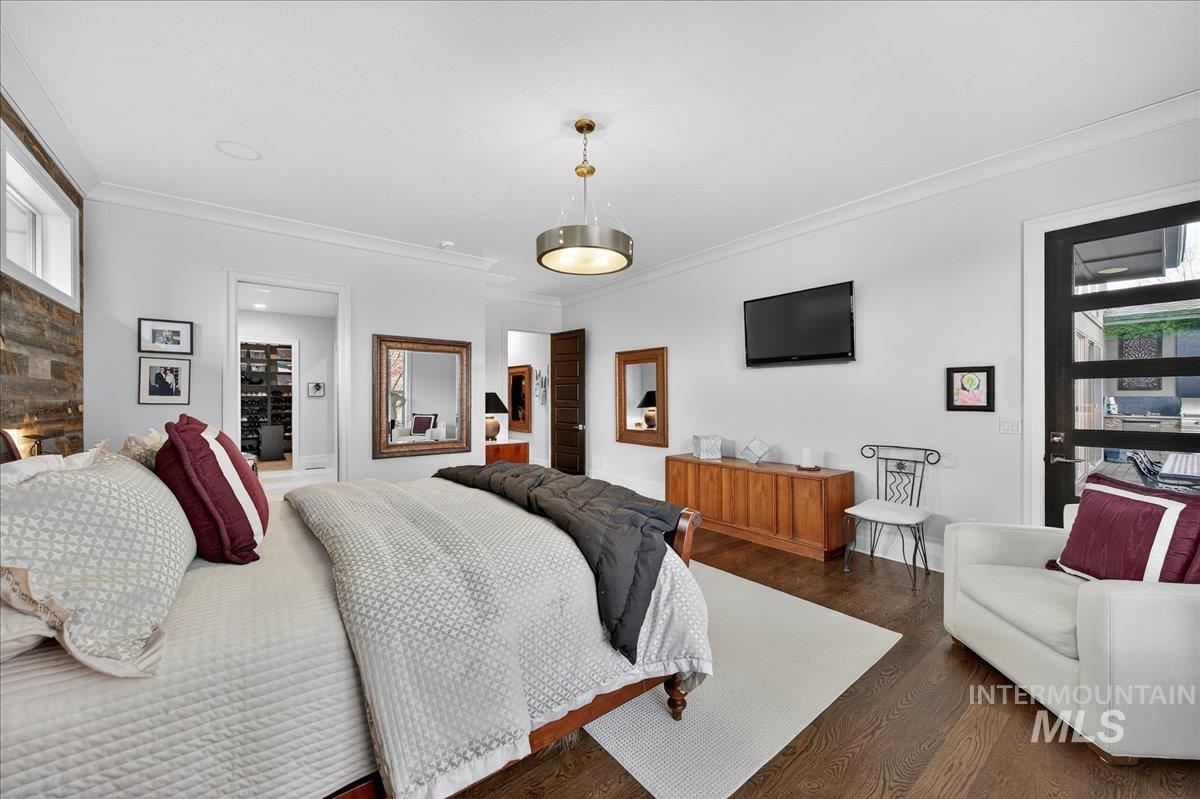 Bedroom featuring crown molding and dark wood finished floors
