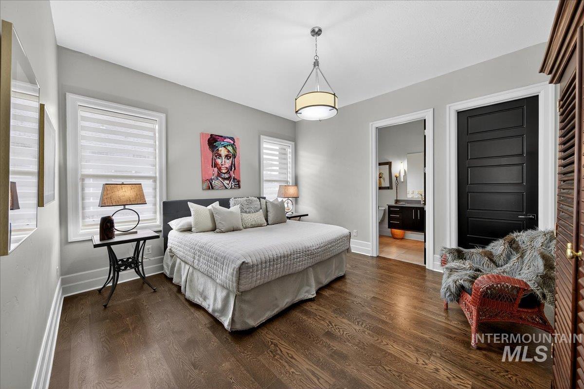 Bedroom with dark wood finished floors and connected bathroom