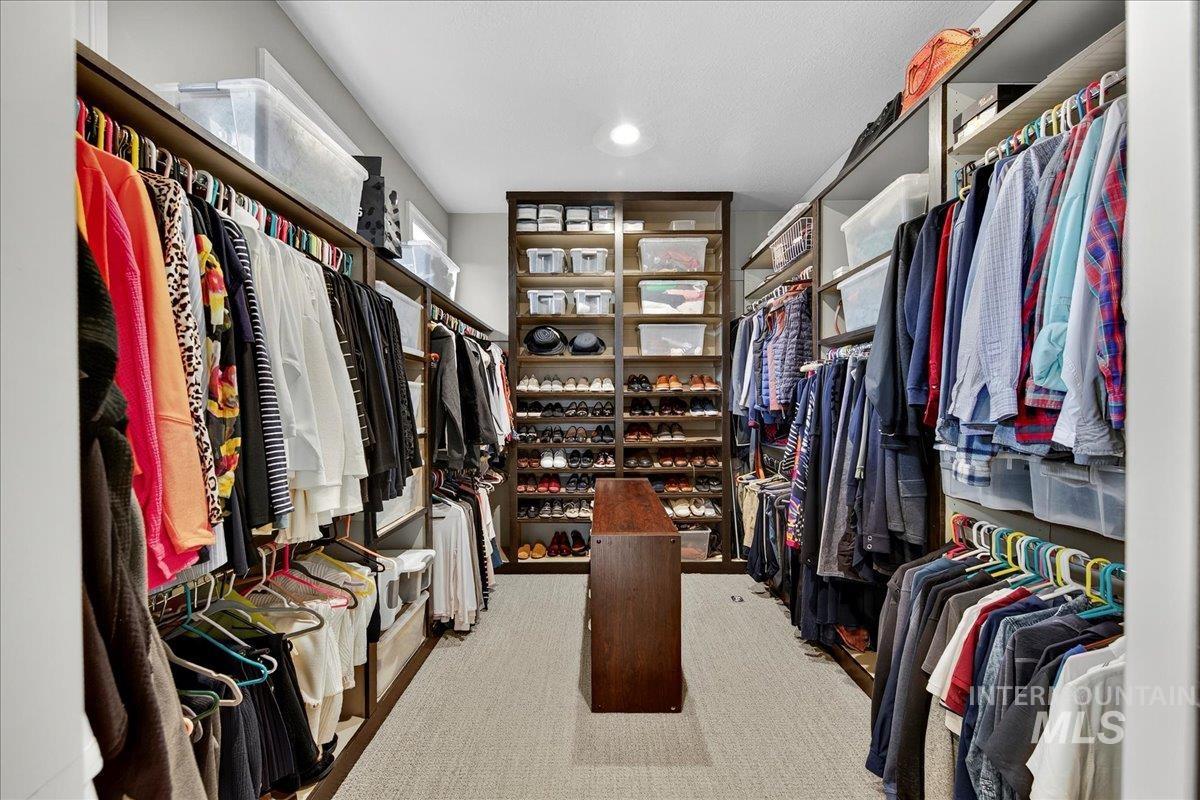 Walk in closet with light colored carpet