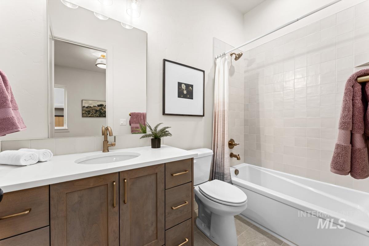 Bathroom featuring a wood-finish vanity with a white countertop and undermount sink