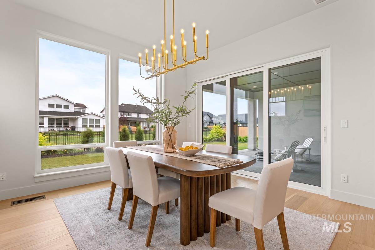 Formal dining space featuring a contemporary chandelier, large windows, and a sliding glass door