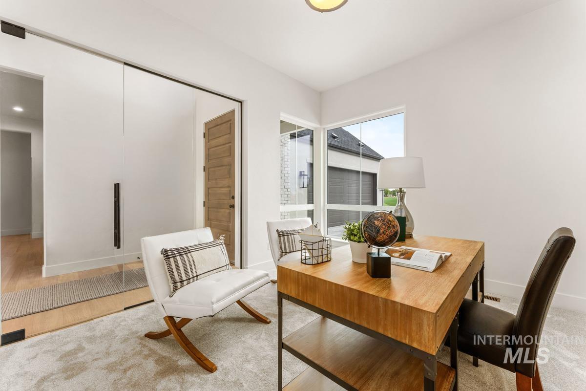 Floor-to-ceiling glass sliding doors complement the light-toned walls and wood-finish flooring