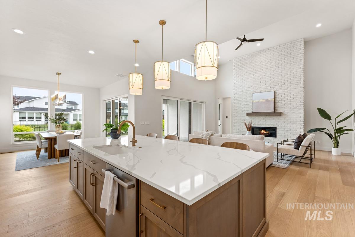 Spacious kitchen island with a white veined countertop, integrated sink, and bronze faucet