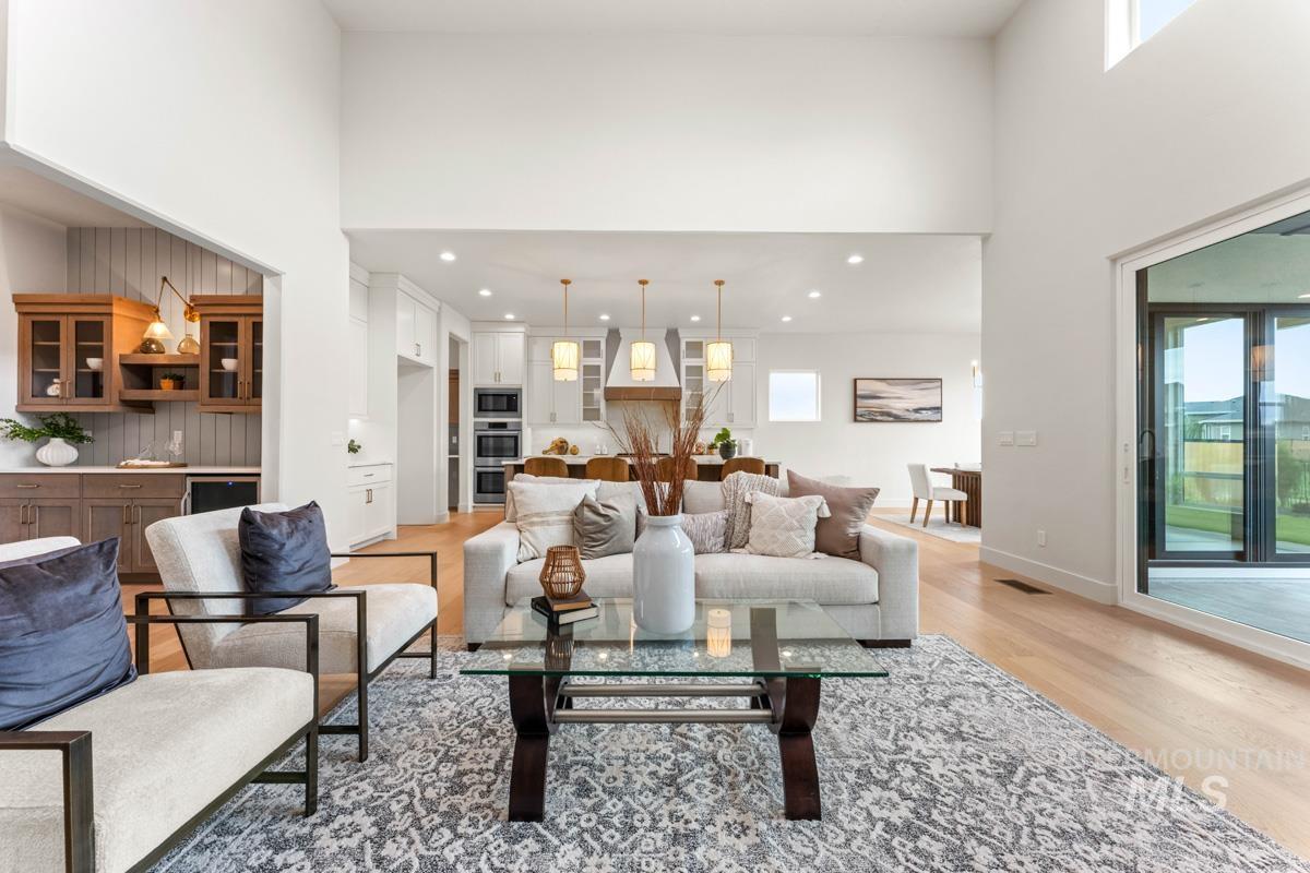 Spacious living area featuring high ceilings, wood-finish flooring, and recessed lighting