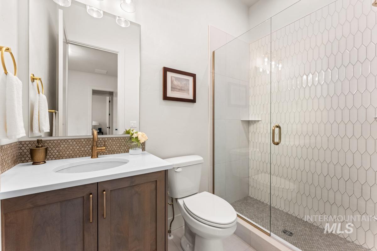 Bathroom featuring a wood-finish vanity with a white countertop and undermount sink