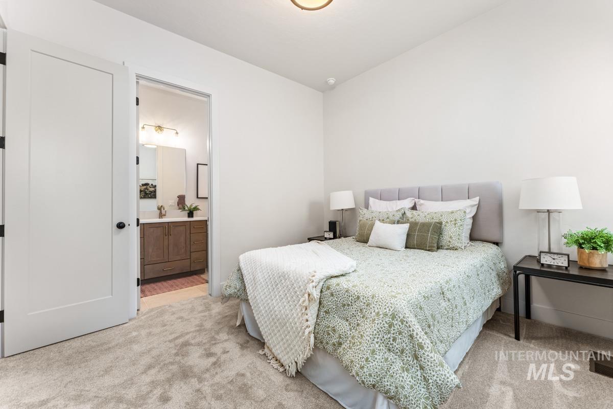 Plush carpeted bedroom with white walls and a light grey upholstered headboard