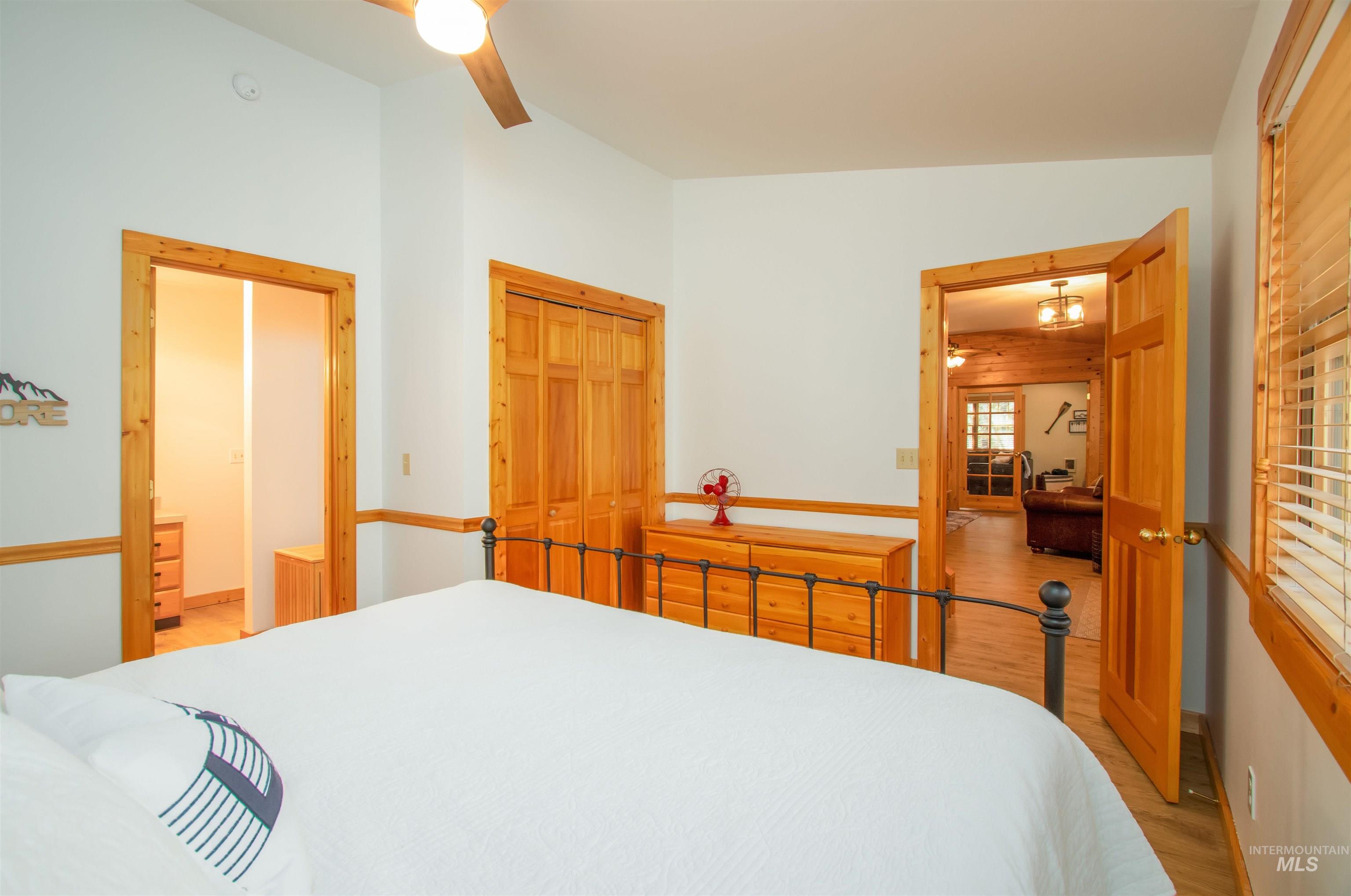 Bedroom with light wood-style flooring, a closet, and a ceiling fan