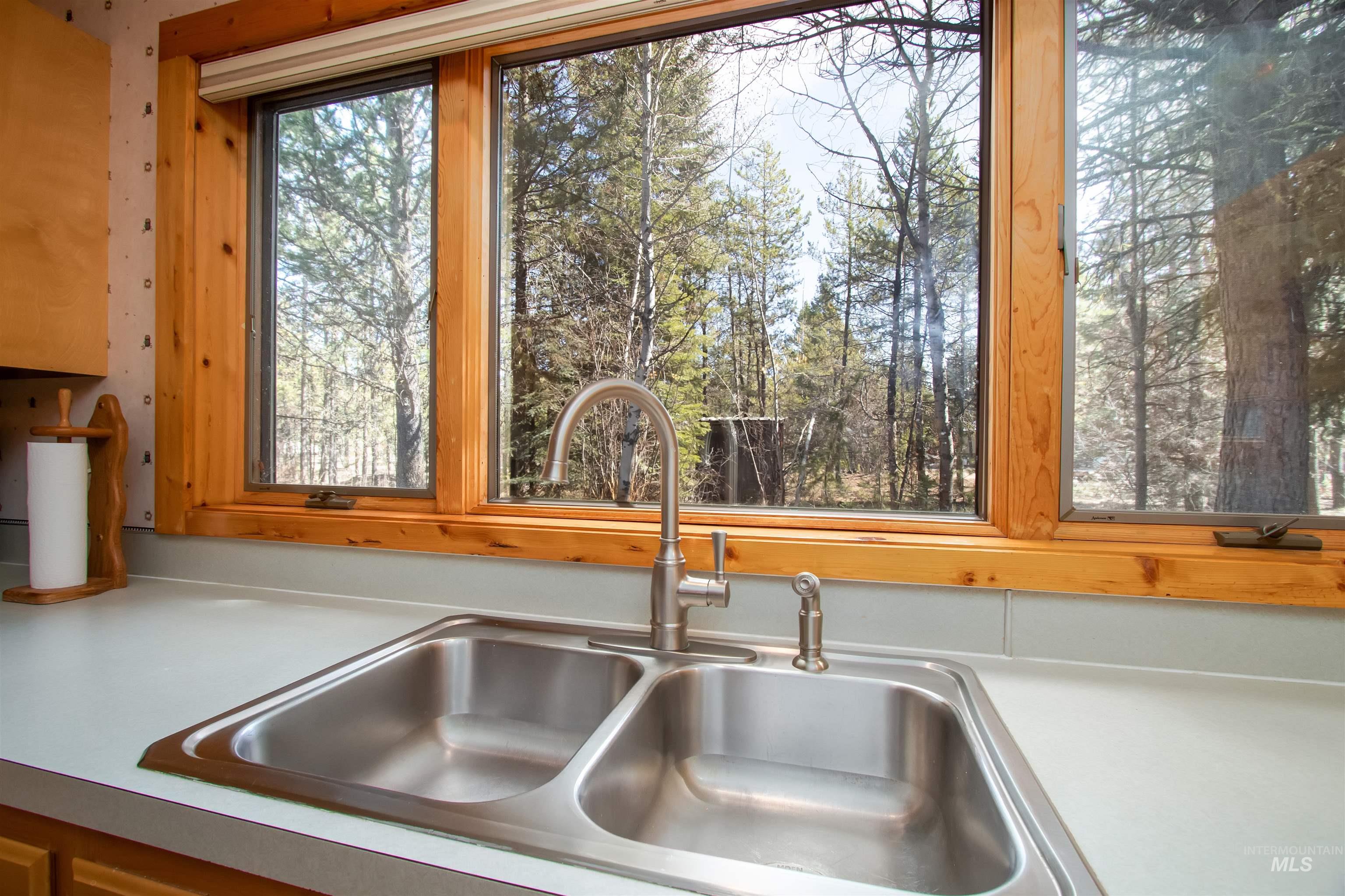 Kitchen view of a sink and light countertops