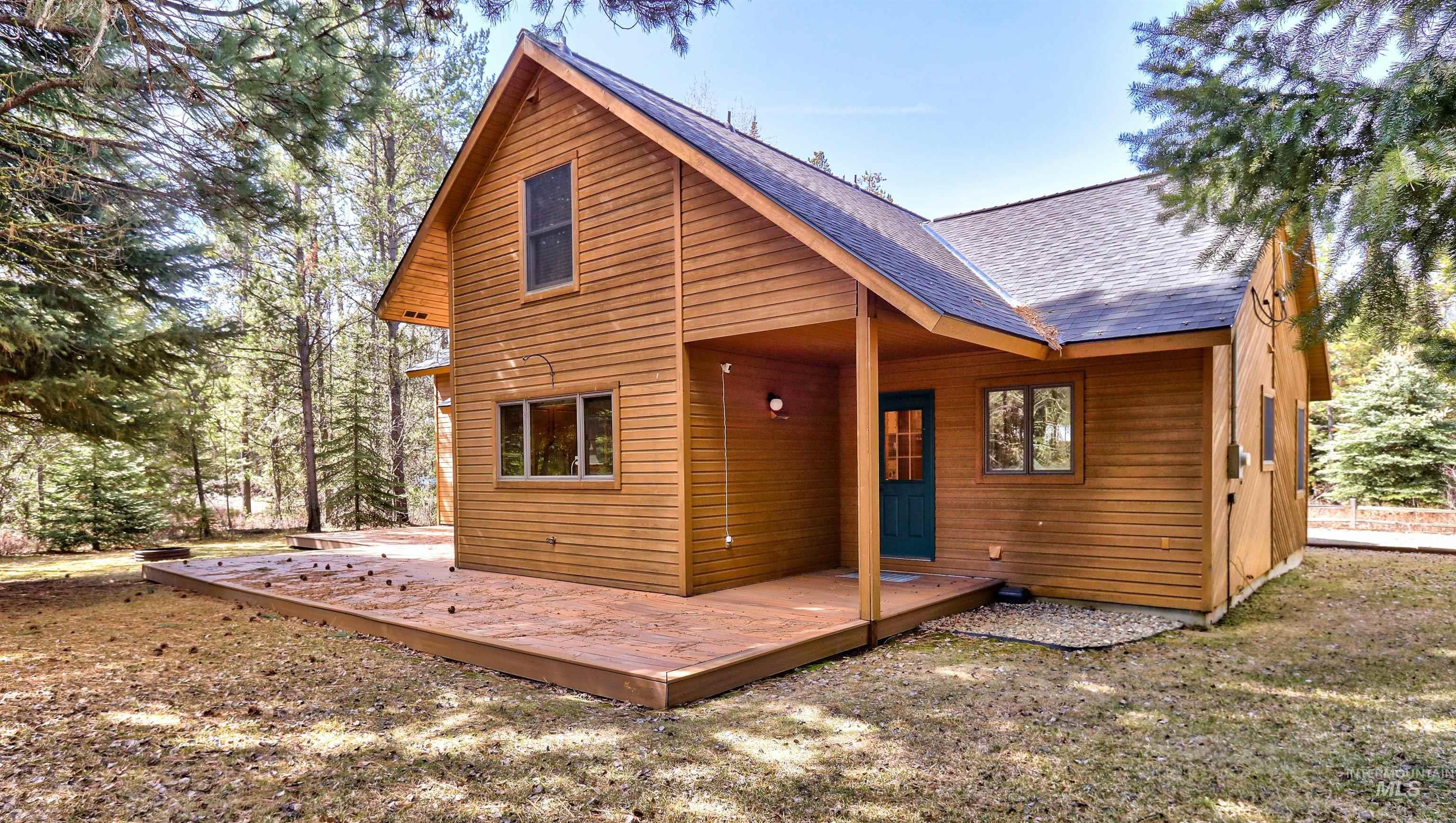 Back of house with a shingled roof and a deck
