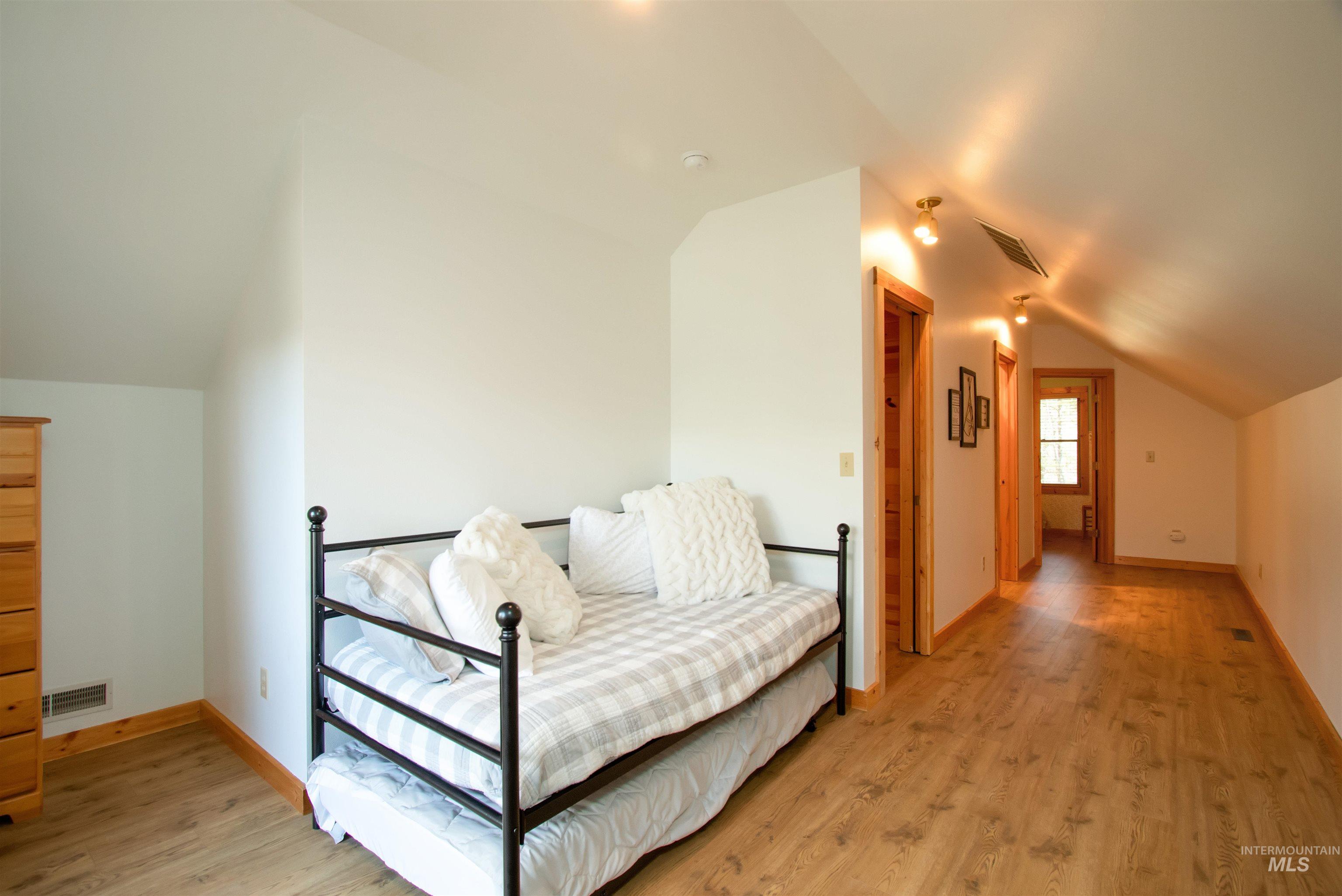 Sitting room featuring lofted ceiling and light wood-type flooring