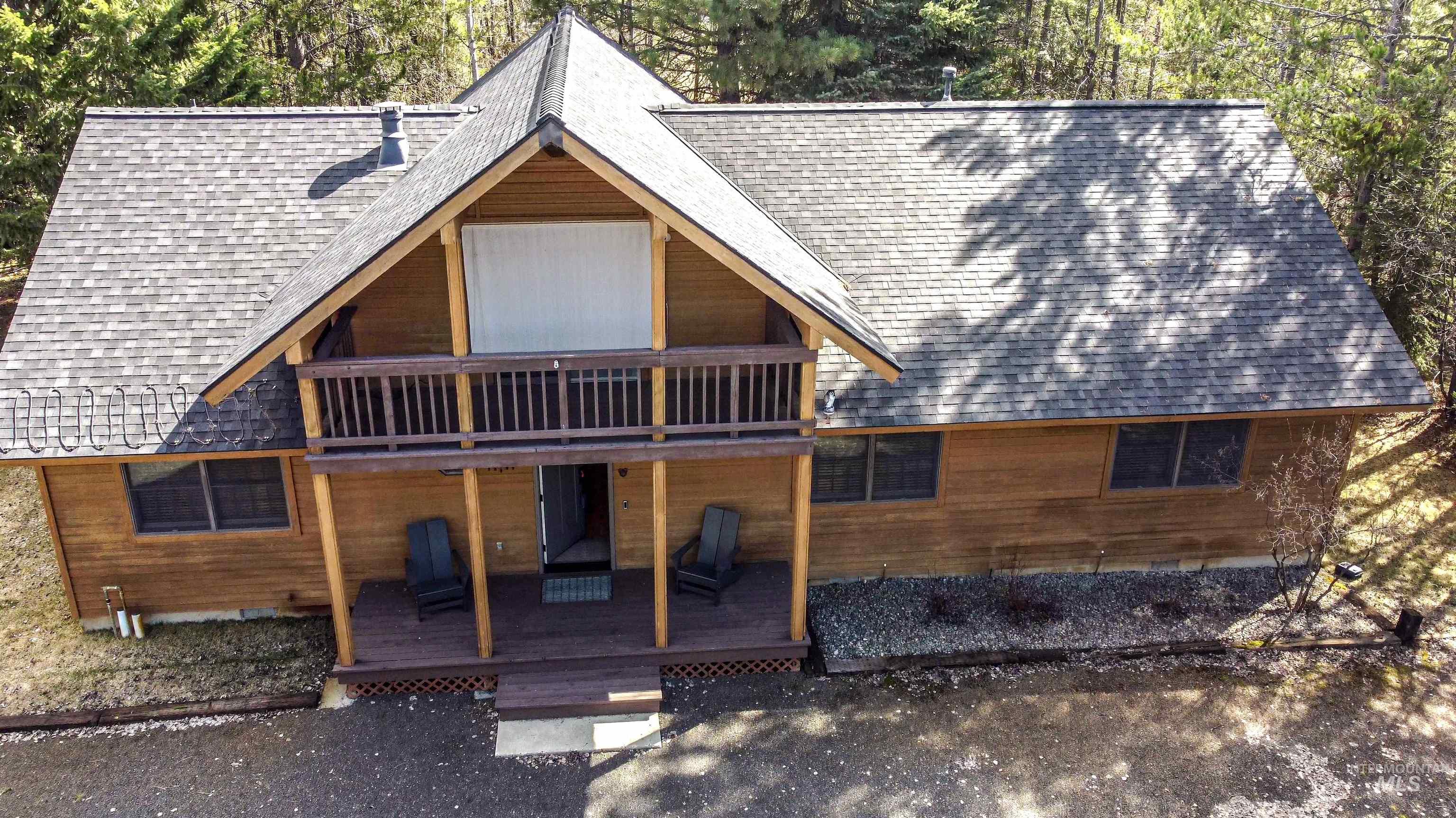 Back of house featuring roof with shingles and a deck