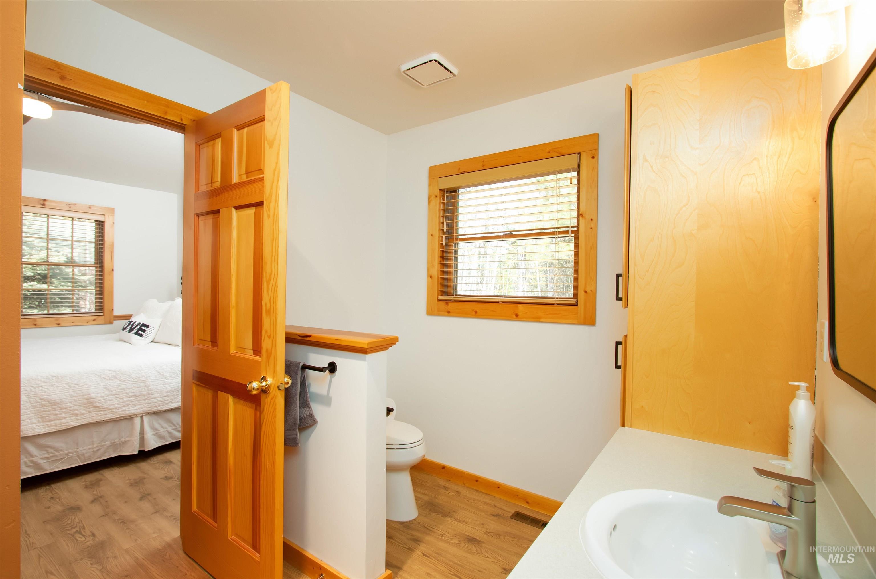 Bathroom featuring vanity, light wood-type flooring, and ensuite bathroom