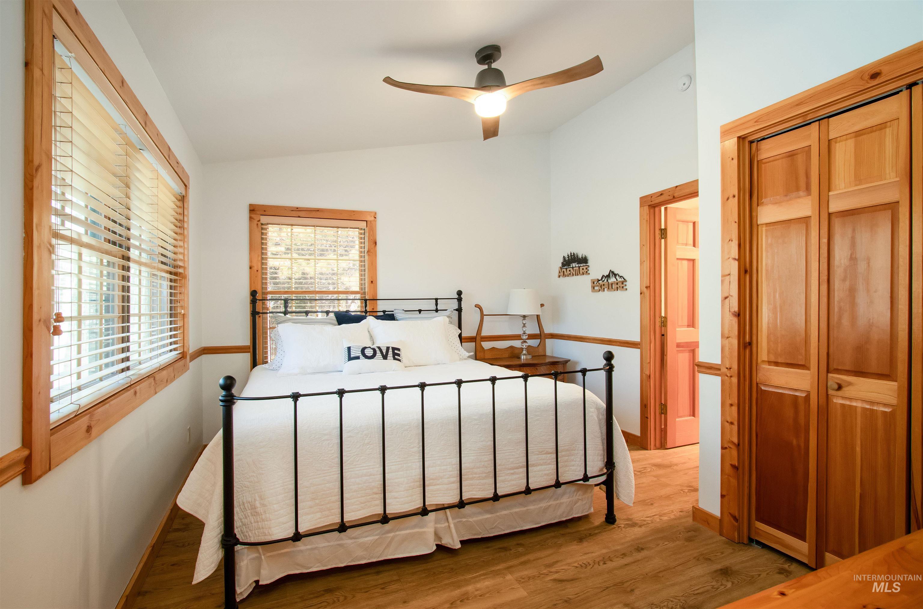 Bedroom featuring wood finished floors, lofted ceiling, ceiling fan, and a closet