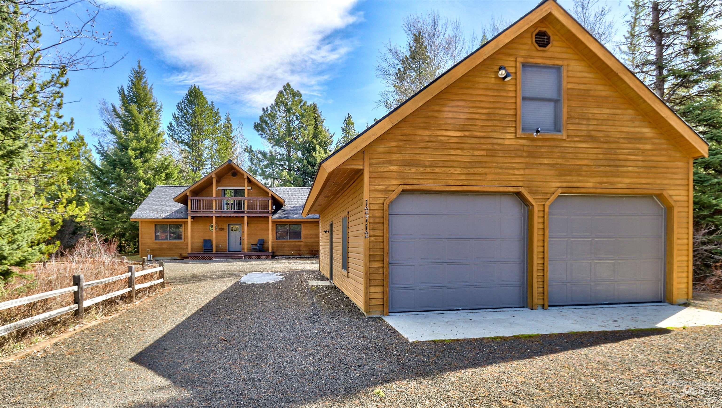 Rustic home featuring an outbuilding, a garage, and a shingled roof