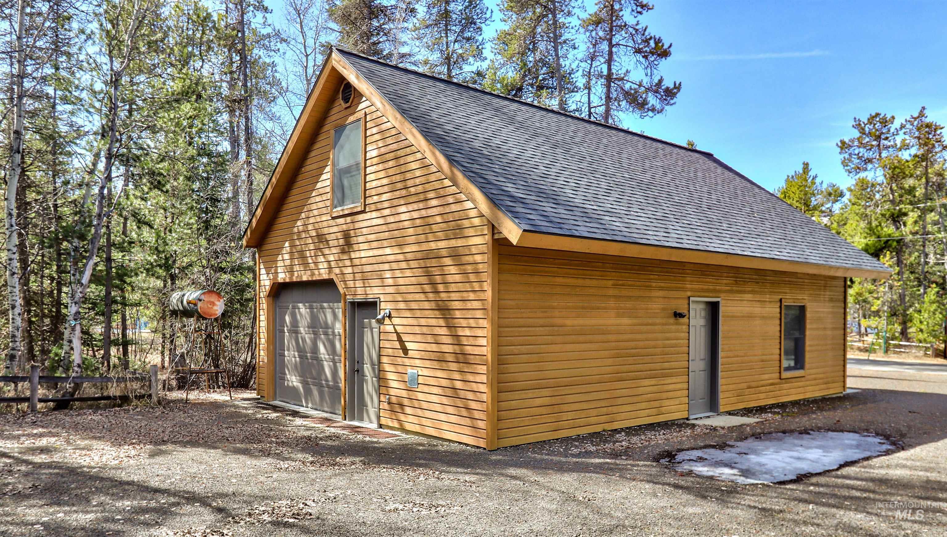 View of home's exterior featuring roof with shingles and a detached garage