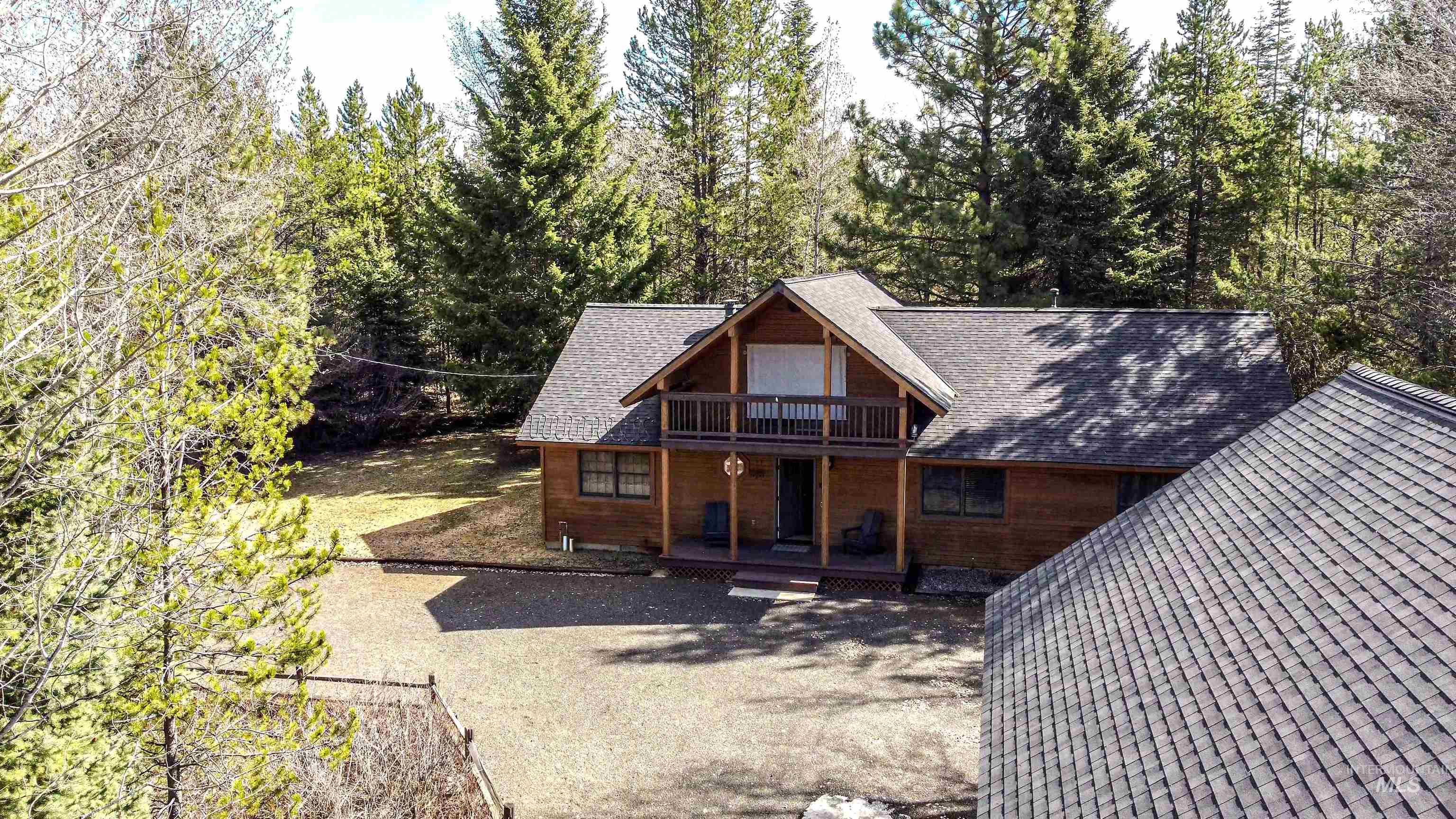 View of front facade featuring a shingled roof, covered porch, and a balcony