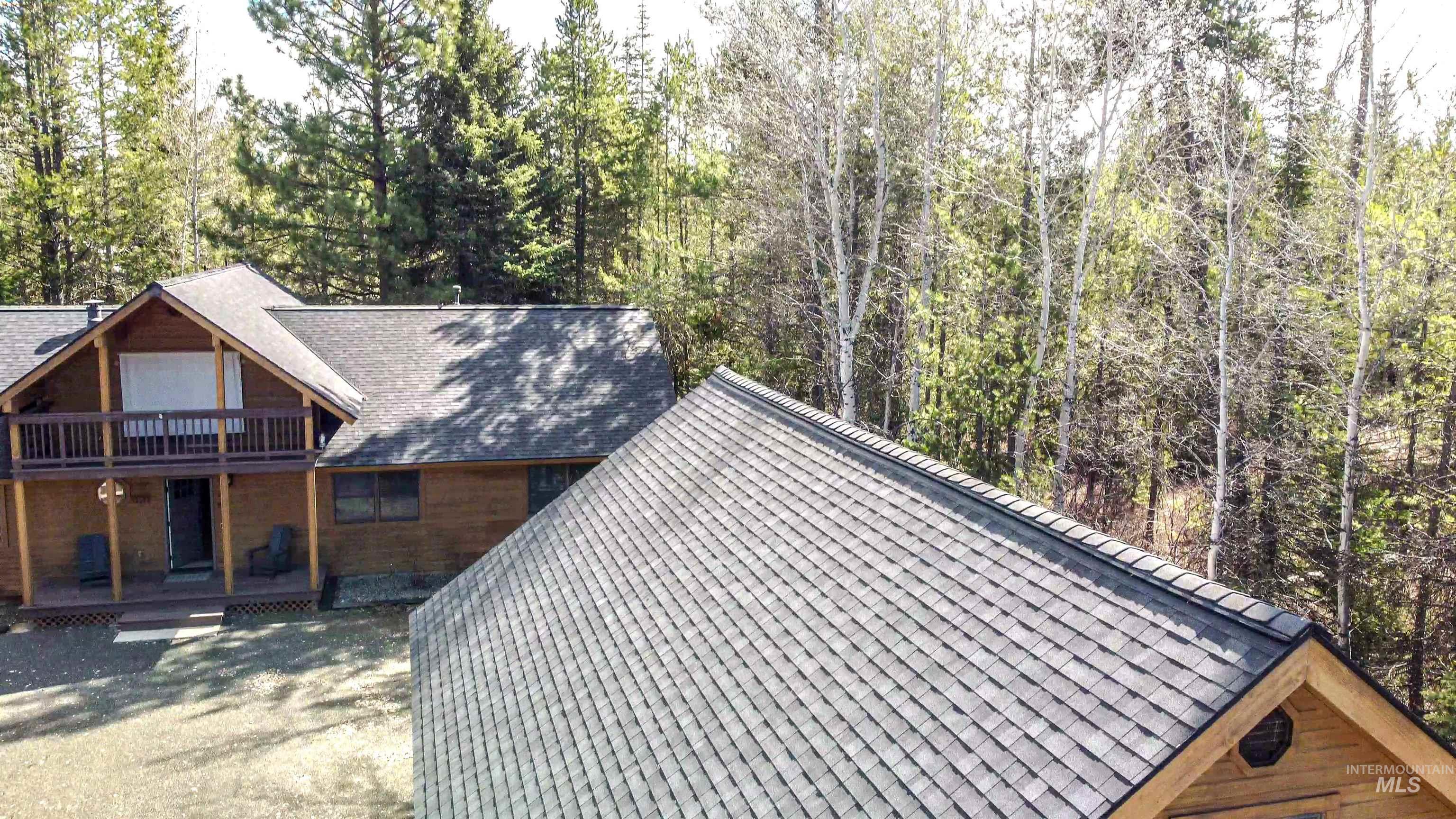 View of property exterior with a shingled roof and covered porch