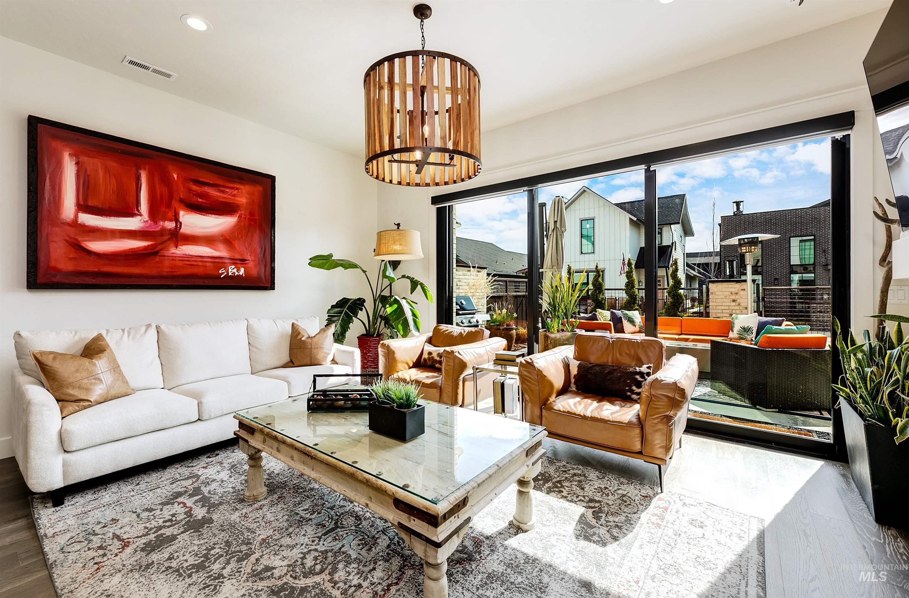 Living room with suspended lighting and wood finished floors