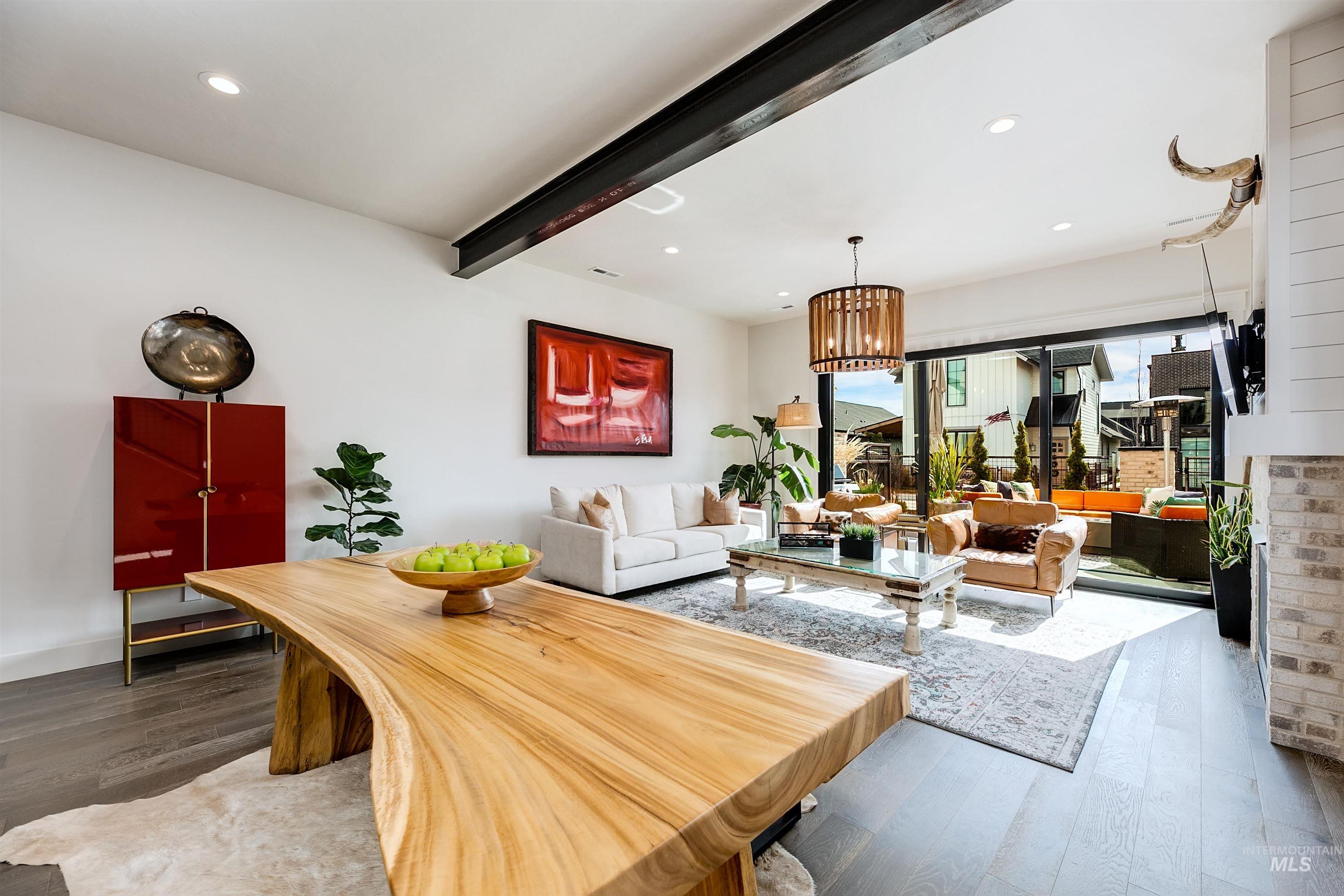 Dining area with beamed ceiling, wood-type flooring, and a chandelier