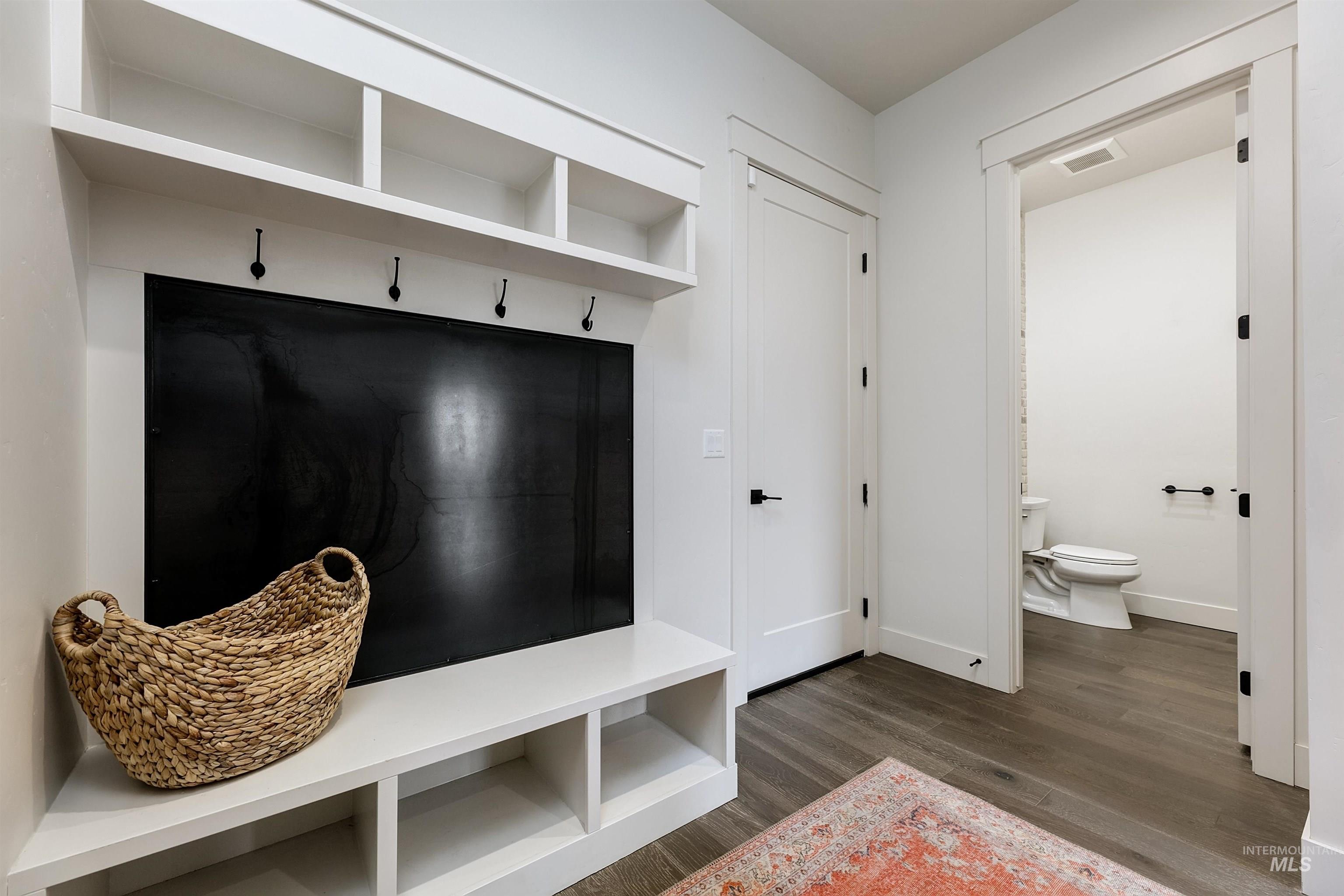 Mudroom with dark wood-style floors and baseboards