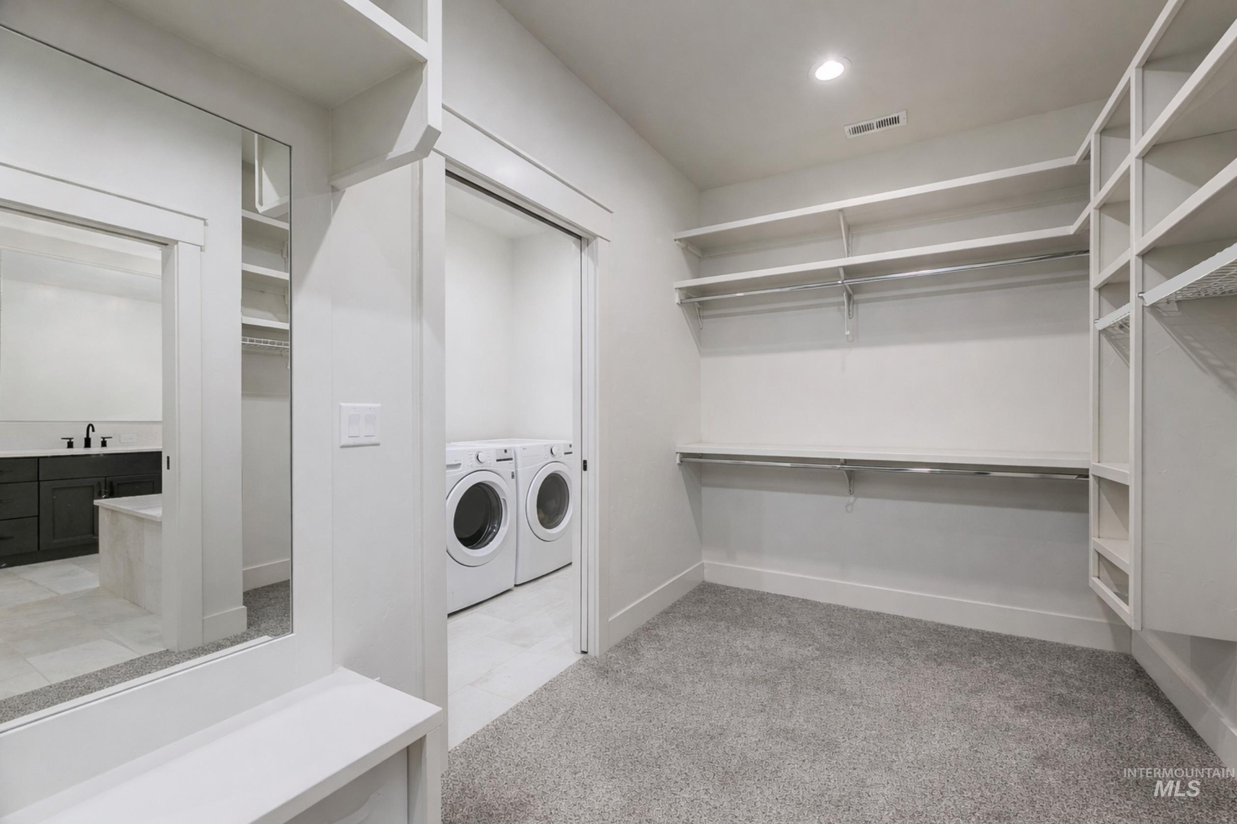 Laundry area with washer and dryer, light carpet, and recessed lighting