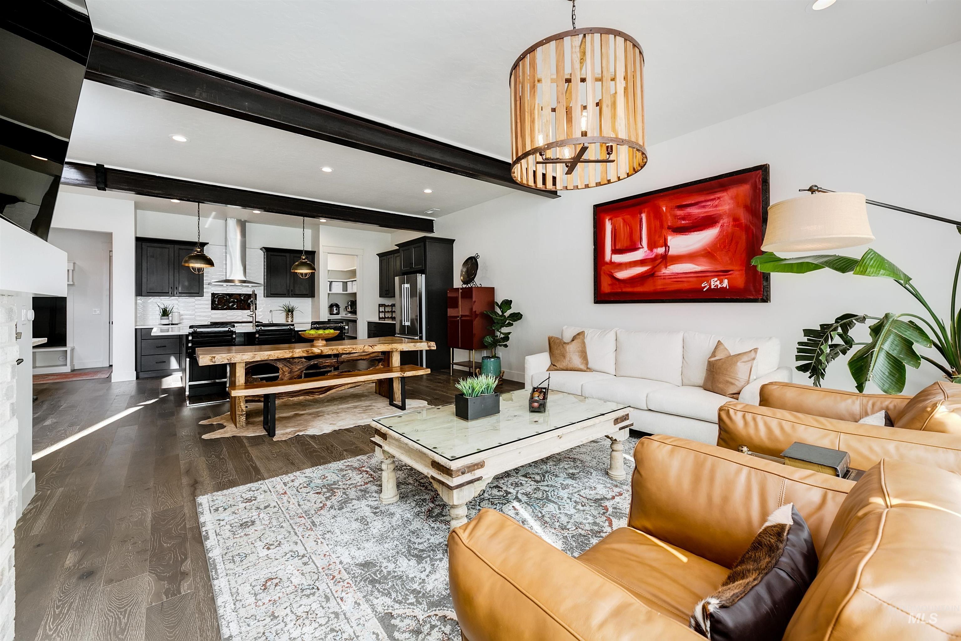 Living room featuring beam ceiling, dark wood finished floors, and a chandelier