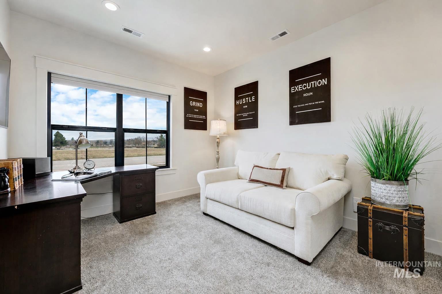 Office space with light carpet and recessed lighting