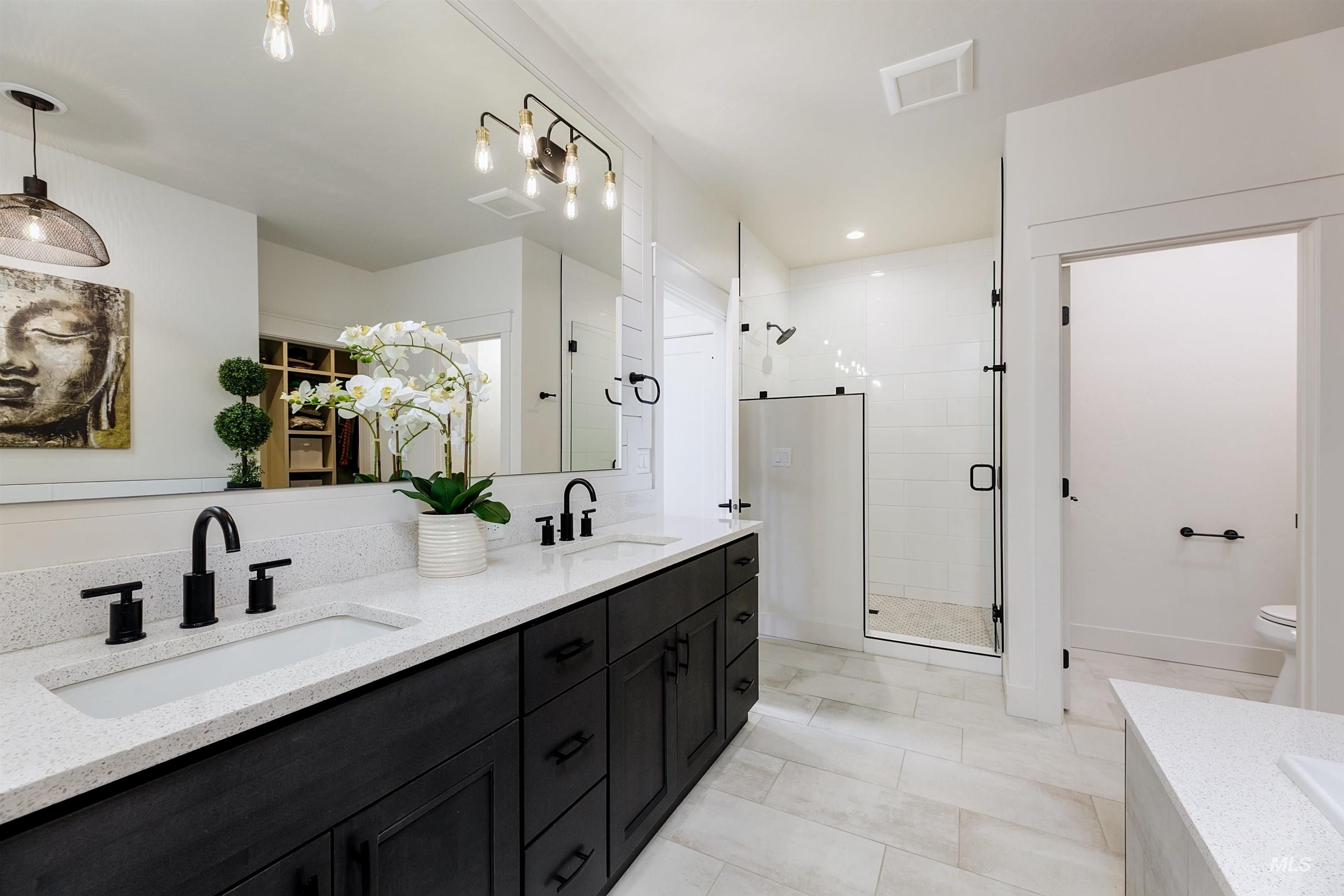 Bathroom with double vanity, a shower stall, and recessed lighting