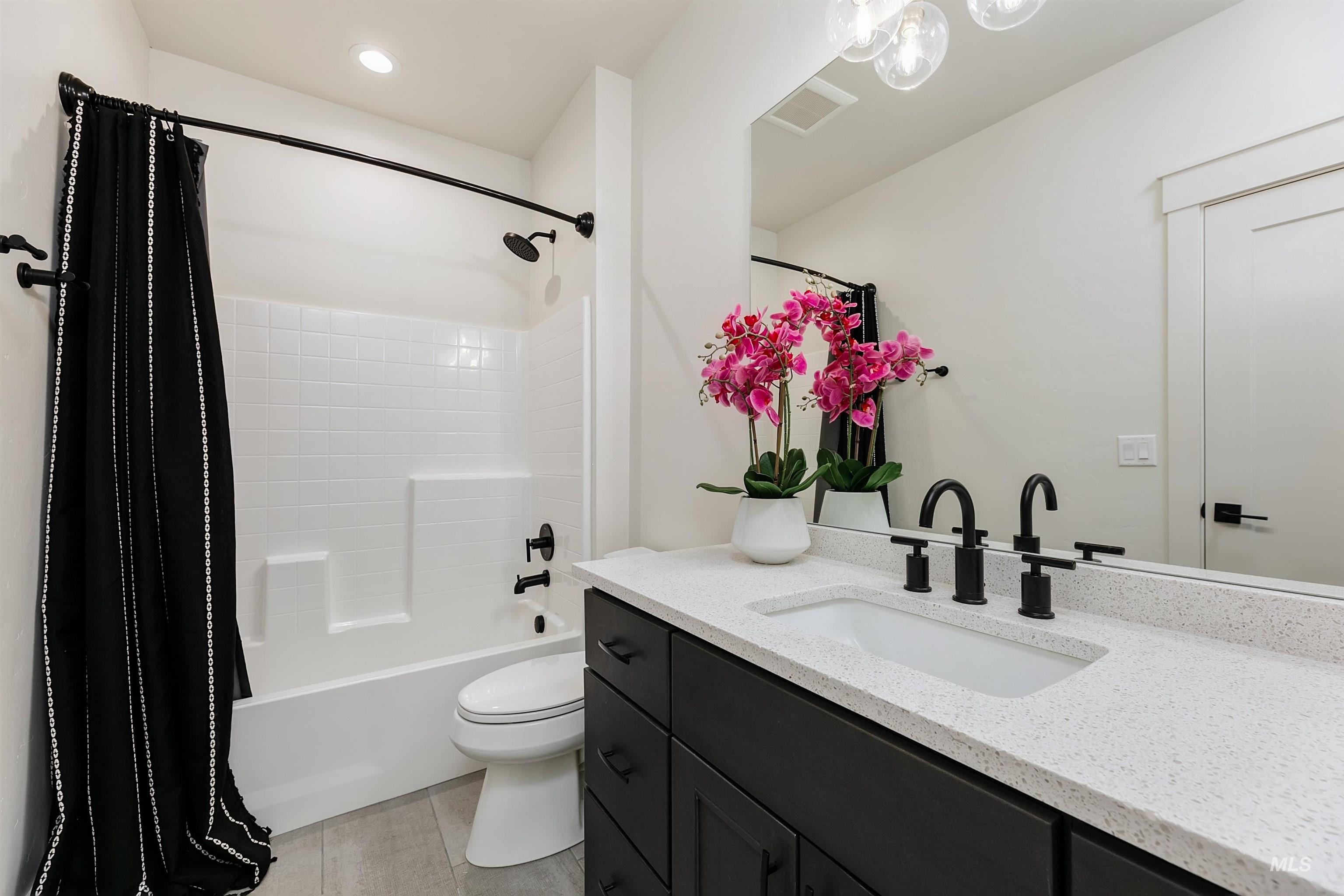 Bathroom featuring vanity, shower / bath combo, and recessed lighting