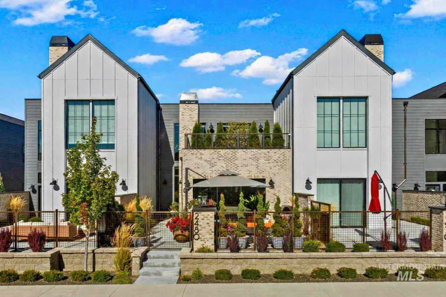 View of front of home featuring board and batten siding, a chimney, and a fenced front yard