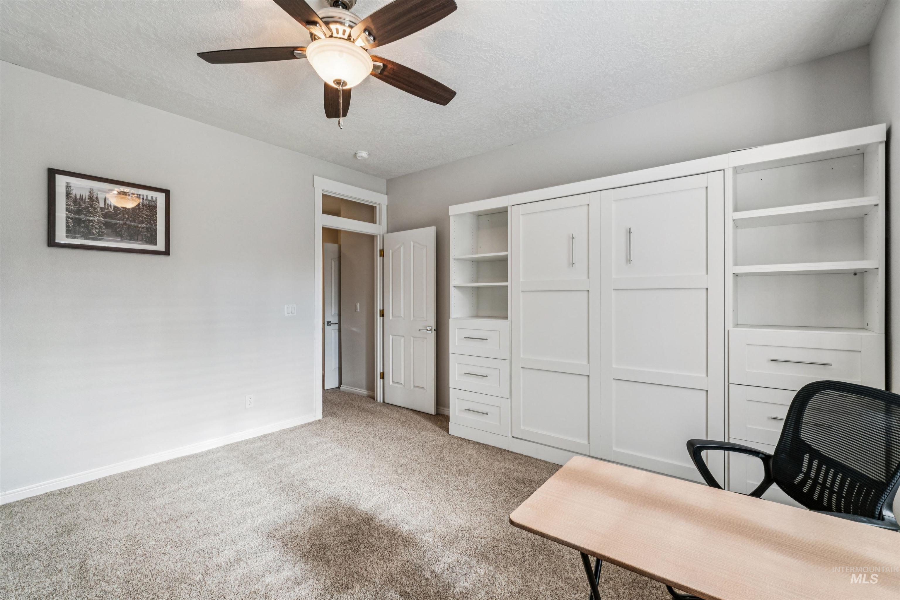 Office with light colored carpet, a textured ceiling, and ceiling fan