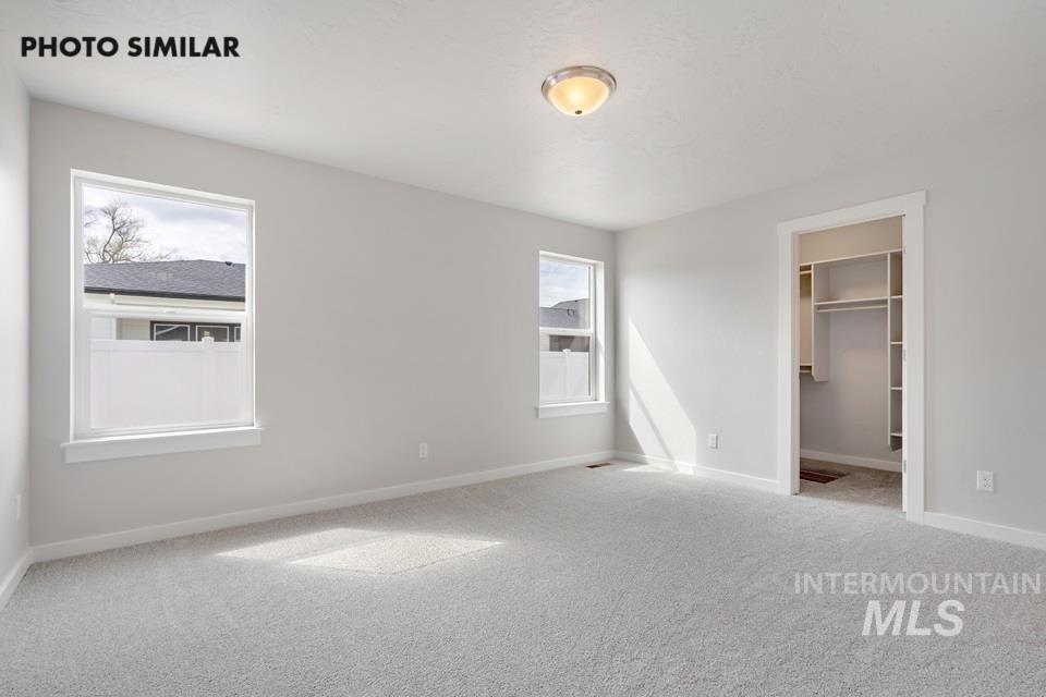 Unfurnished bedroom featuring carpet and a spacious closet