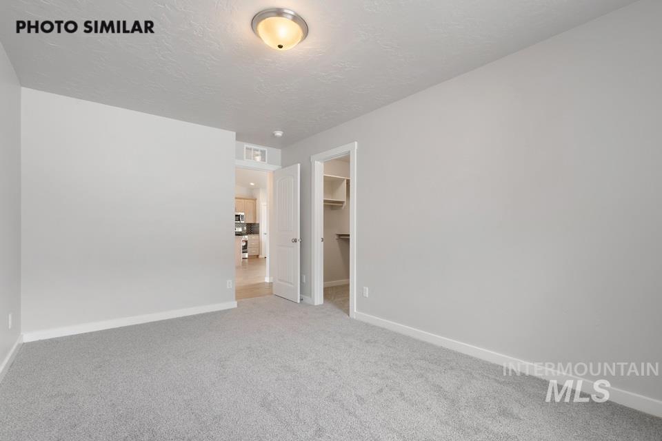 Carpeted empty room featuring baseboards