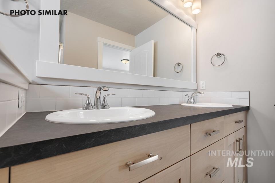 Bathroom with decorative backsplash and double vanity