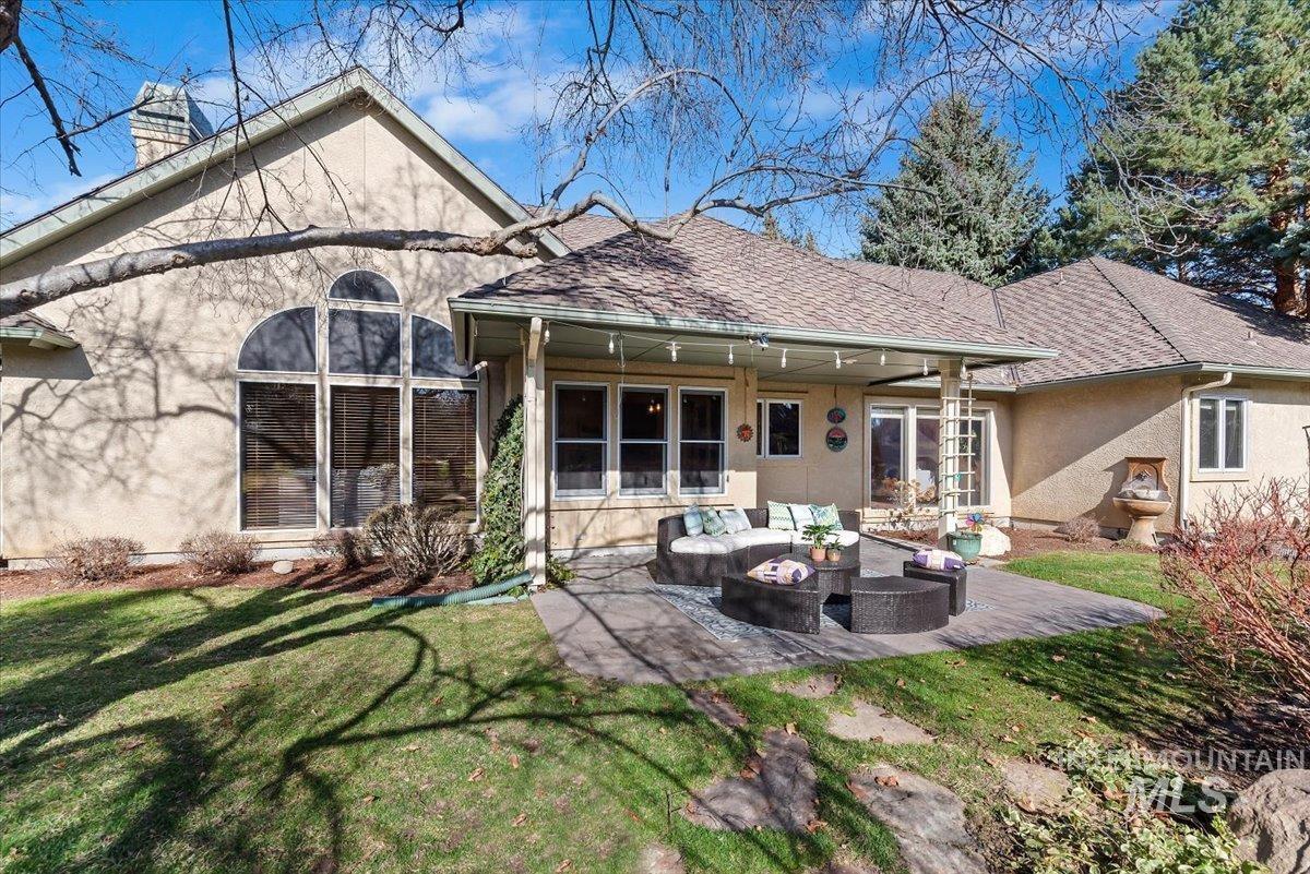 Back of property featuring stucco siding, an outdoor lounge area, and a yard