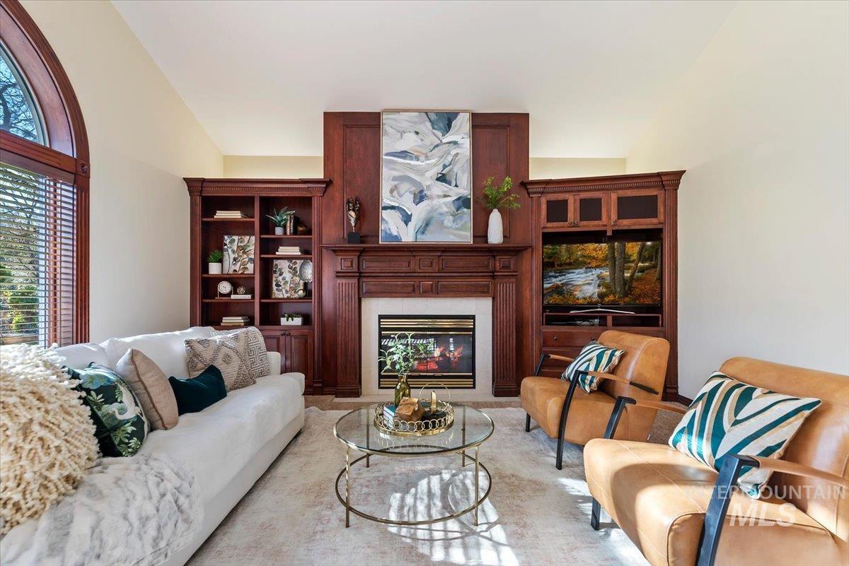 Living room with a glass covered fireplace and vaulted ceiling