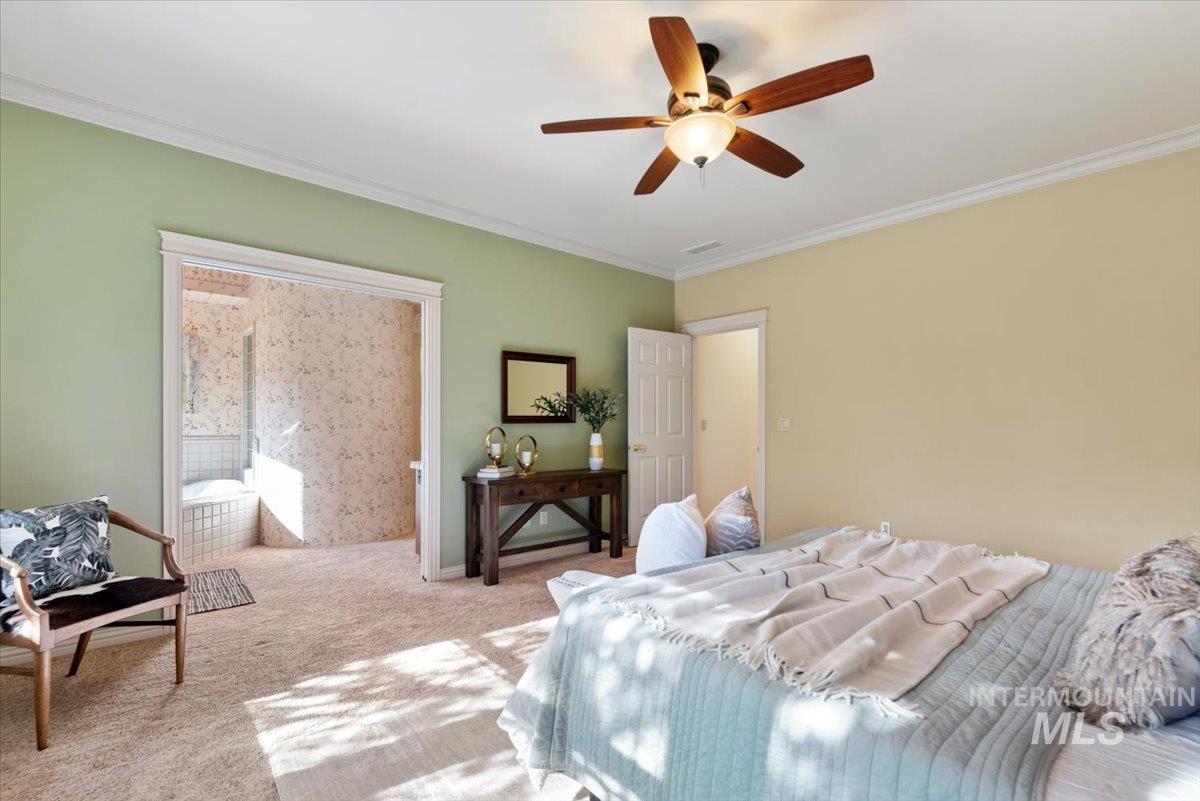 Bedroom with ornamental molding, carpet floors, and ceiling fan