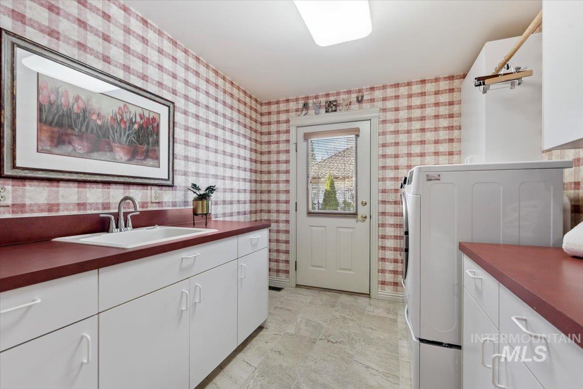 Laundry area with cabinet space and baseboards