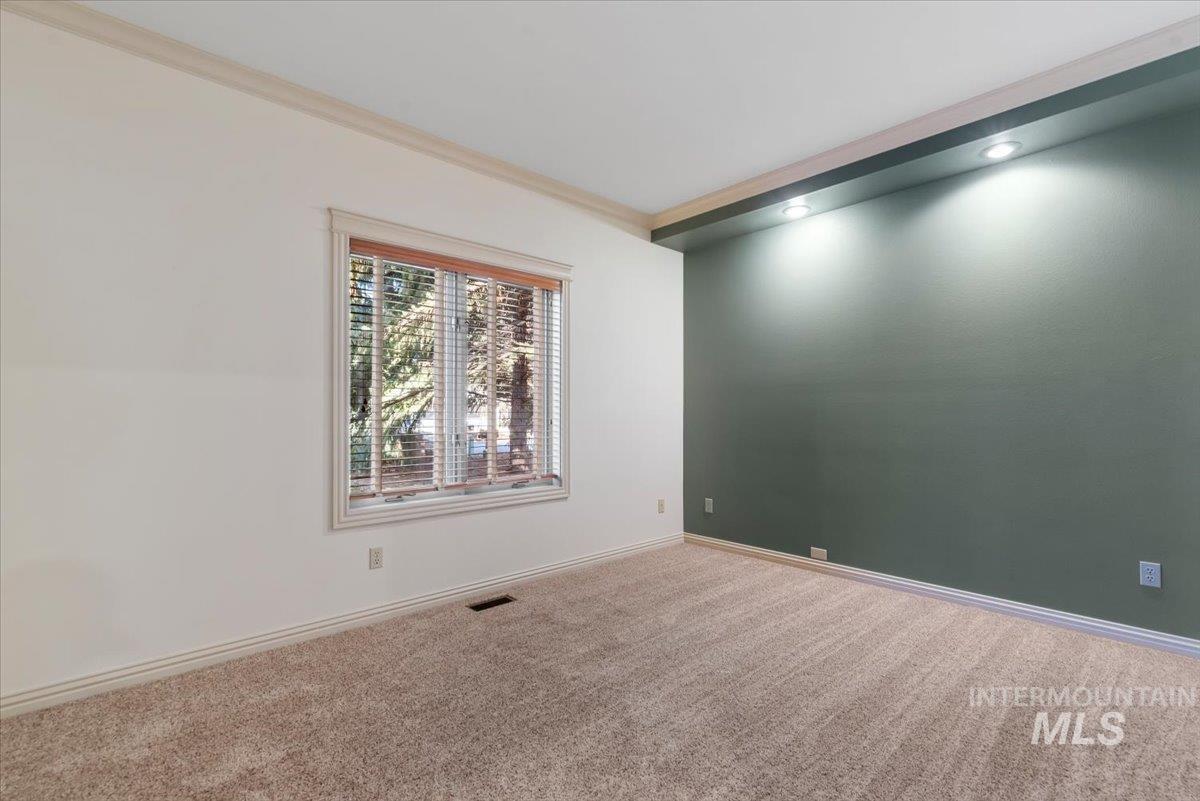 Carpeted empty room featuring crown molding and recessed lighting