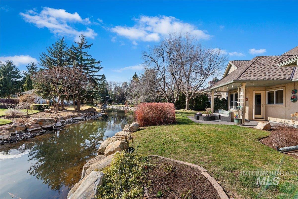 View of grassy yard with a small pond, a patio, and outdoor lounge area