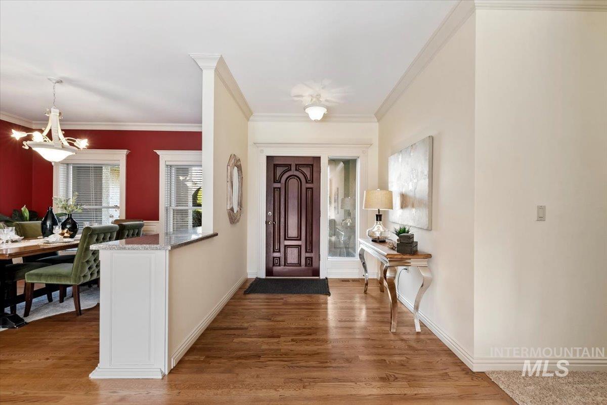 Entryway featuring light wood-type flooring and crown molding