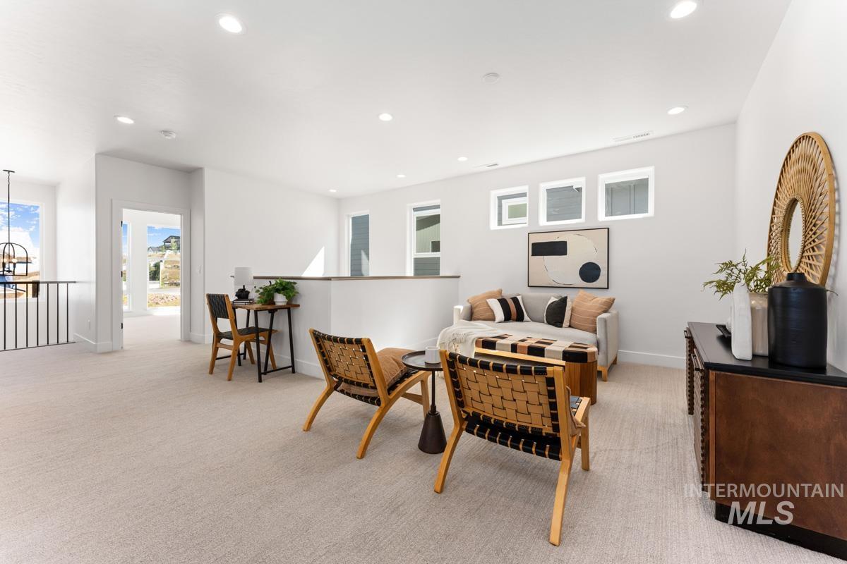 Open-concept loft space featuring recessed lighting and light-toned carpeting