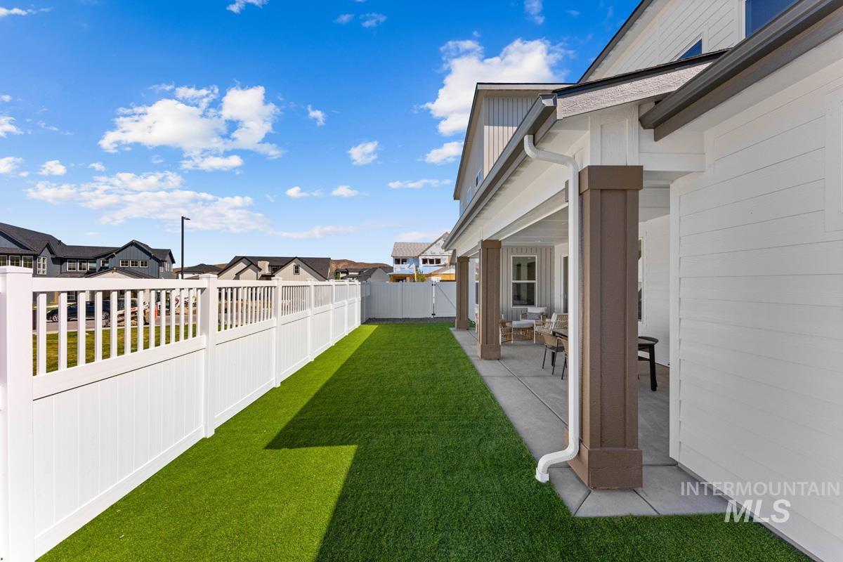 Covered patio featuring robust square columns, concrete flooring, and a white gutter system