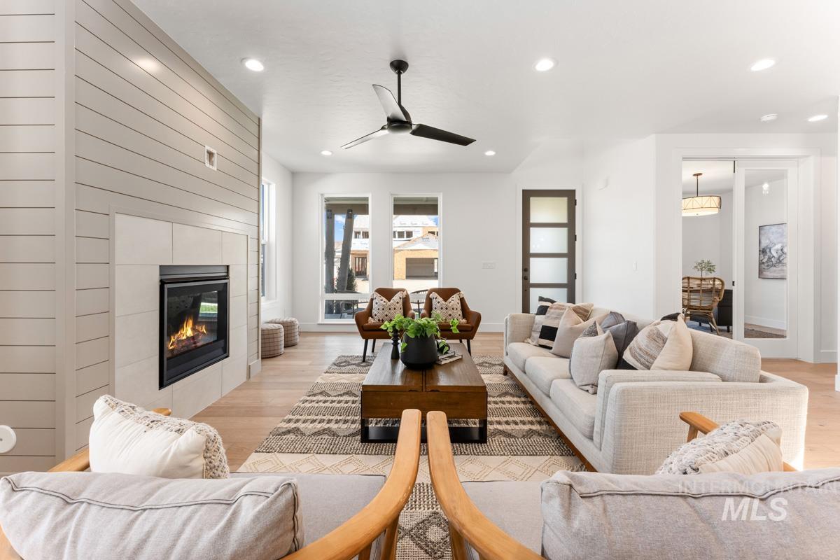 Spacious living area featuring a modern fireplace with a shiplap accent wall and light-toned tile surround